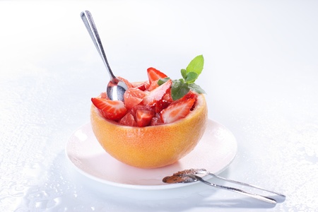 Fruit salad in hollowed-out grapefruit stuffed with strawberryの写真素材