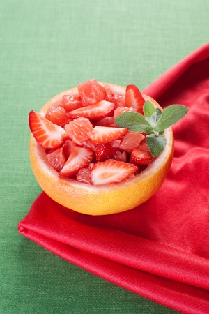 Fruit salad in hollowed-out grapefruit stuffed with strawberryの写真素材