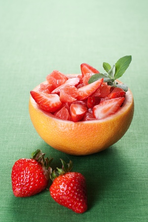 Fruit salad in hollowed-out grapefruit stuffed with strawberryの写真素材