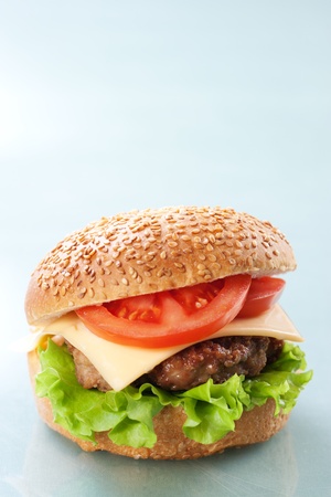 Cheeseburger with tomatoes and lettuce on grey backgroundの写真素材