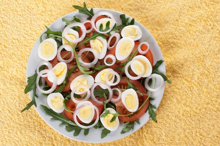 Healthy salad with tomatoes, onions, eggs and rucolaの写真素材
