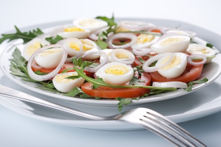 Healthy salad with tomatoes, onions, eggs and rucolaの写真素材