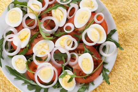 Healthy salad with tomatoes, onions, eggs and rucolaの写真素材