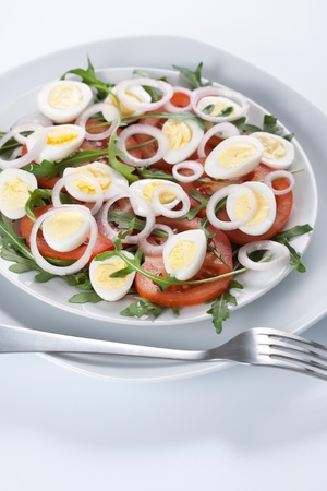 Healthy salad with tomatoes, onions, eggs and rucolaの写真素材