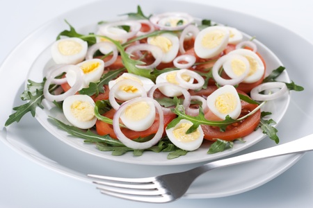 Healthy salad with tomatoes, onions, eggs and rucolaの写真素材