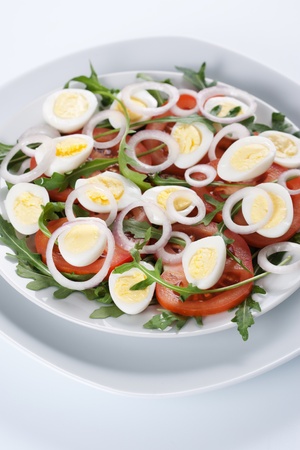 Healthy salad with tomatoes, onions, eggs and rucolaの写真素材