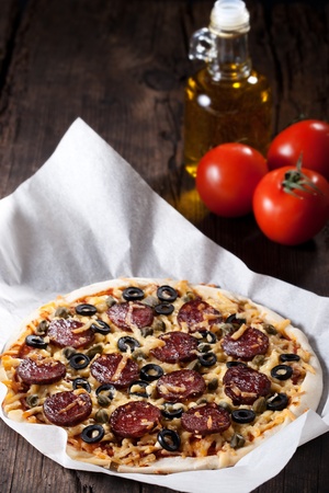 Homemade pizza with salami, cheese and black olives.の写真素材