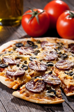 Homemade pizza with salami, cheese and black olives.の写真素材
