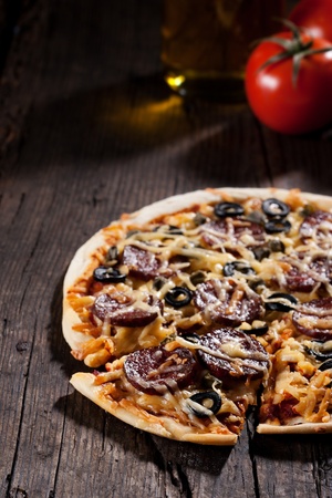 Homemade pizza with salami, cheese and black olives.の写真素材
