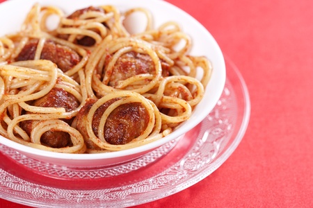 Pasta with meatballs and tomato sauce on red background の写真素材