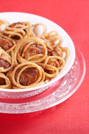 Pasta with meatballs and tomato sauce on red background の写真素材