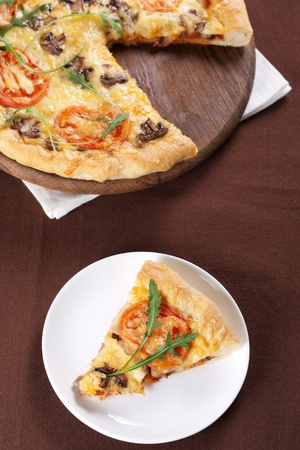 Fresh baked pizza with mushroom, tomatoes and rucolaの写真素材