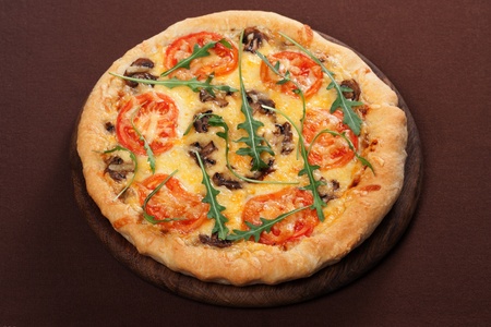Fresh baked pizza with mushroom, tomatoes and rucolaの写真素材