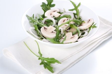 Fresh salad with rucola, mushrooms and onion in bowlの写真素材