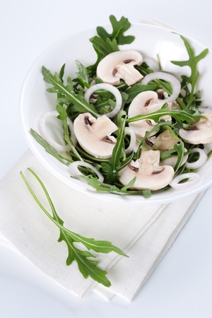 Fresh salad with rucola, mushrooms and onion in bowlの写真素材