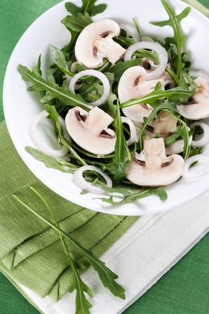 Fresh salad with rucola, mushrooms and onion in bowlの写真素材