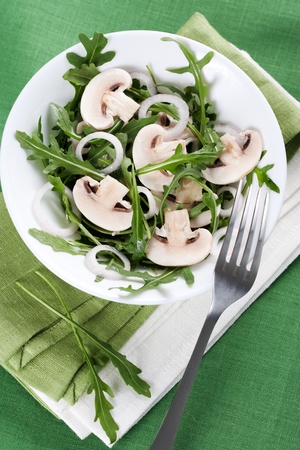 Fresh salad with rucola, mushrooms and onion in bowlの写真素材