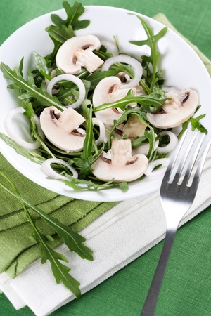 Fresh salad with rucola, mushrooms and onion in bowlの写真素材