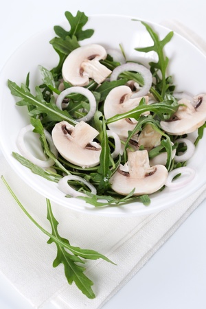 Fresh salad with rucola, mushrooms and onion in bowlの写真素材