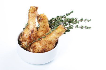 Roasted chicken legs with thyme in a bowlの写真素材
