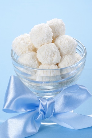 Homemade coconut candies in a bowl with a bowの写真素材