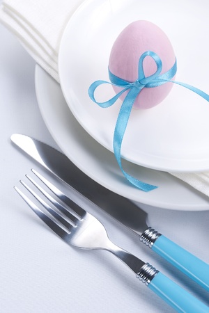 Easter table setting with plates, napkin, silverware and easter eggの写真素材