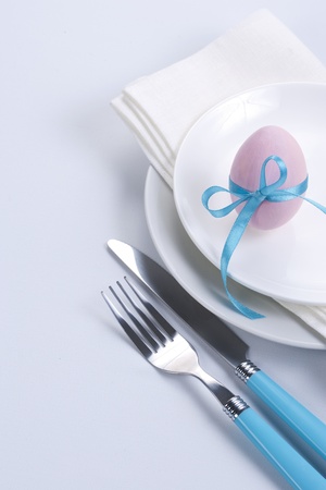Easter table setting with plates, napkin, silverware and easter eggの写真素材