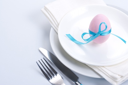 Easter table setting with plates, napkin, silverware and easter egg