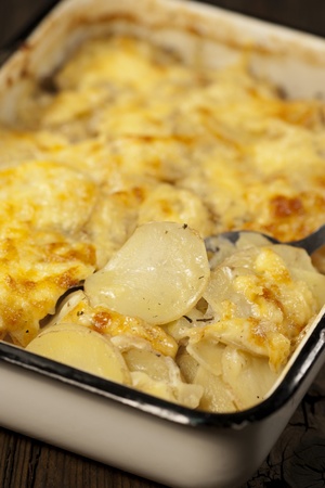 Potato gratin dauphinoise in the pan on rustic backgroundの写真素材