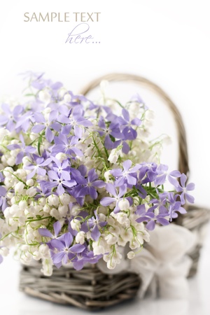 Bouquet of spring flowers in basket on white background の写真素材