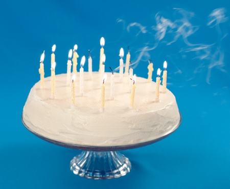 Birthday cake with smoke coming from blown out candles の写真素材