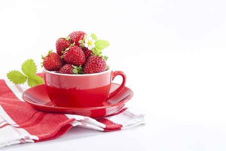 Strawberries in red cup on white backgroundの写真素材