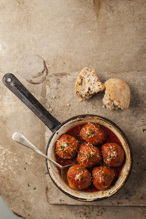 Meatballs cooked in tomato sauce in pan on grey backroundの写真素材