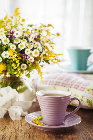 Tea and beautiful wildflowers on wooden backgroundの写真素材