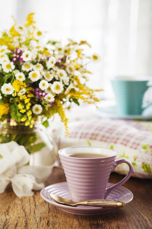 Tea and beautiful wildflowers on wooden backgroundの写真素材