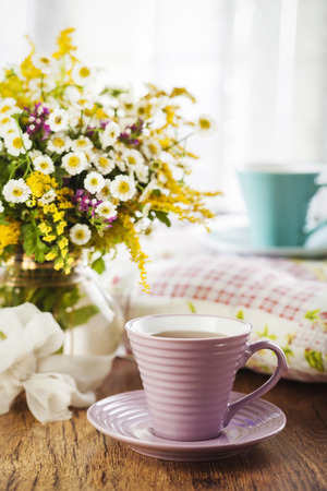 Tea and beautiful wildflowers on wooden backgroundの写真素材