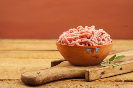 Raw red mince in bowl on wooden backgroundの写真素材