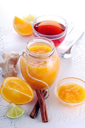 Orange jam and tea on a white tableの写真素材