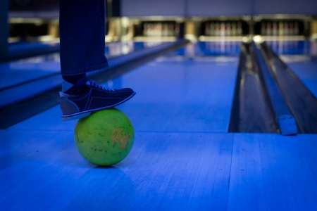 a man put his foot on a bowling ballの写真素材