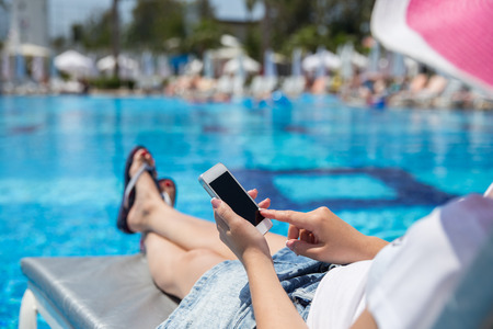 woman on sunbed waering beautiful pink hatの写真素材