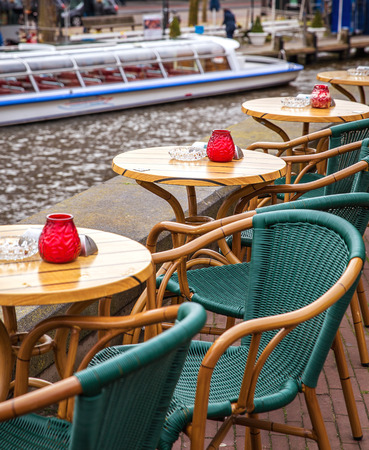 Street cafe with boat on background in Amsterdam, Netherlandsの写真素材