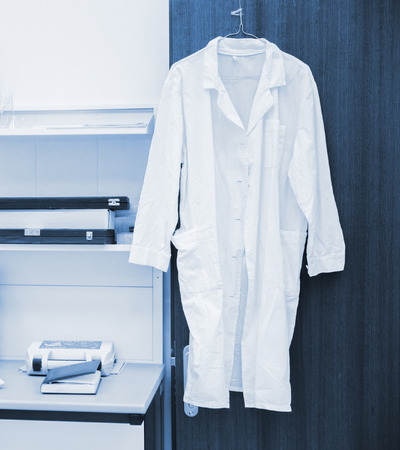 white robe hanging on a door in laboratoryの写真素材