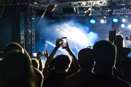 silhouettes of crowd at concert near stageの写真素材