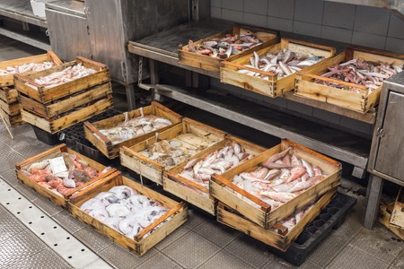 Local fish market with wooden boxes with seafood