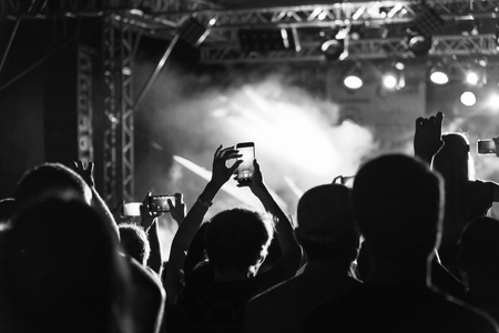 Black and White Silhouette of People in Crowd at a Music Festival. Concert with backlit standing dancing peopleの写真素材