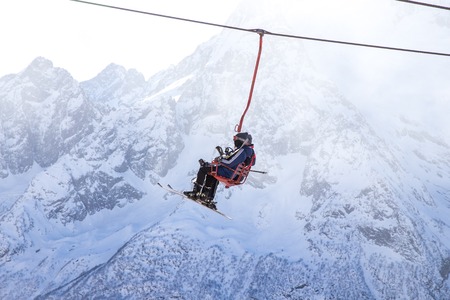 DOMBAI, RUSSIA - JANUARY 3, 2014: People are lifting on open lft high up in Caucasus mountainsのeditorial素材