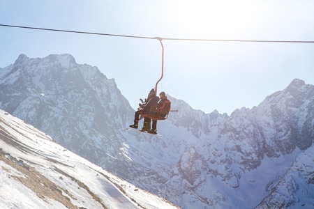 DOMBAI, RUSSIA - JANUARY 3, 2014: People are lifting on open lft high up in Caucasus mountains