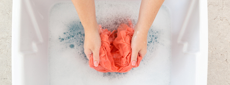 Female hands washing color clothes in sinkの写真素材