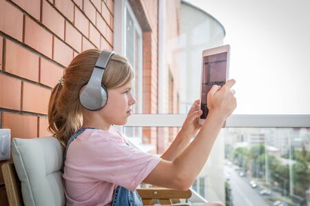 A young girl enjoying listening to music on her headphone with tabletの写真素材
