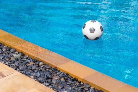 Soccer ball floating in the swimming pool